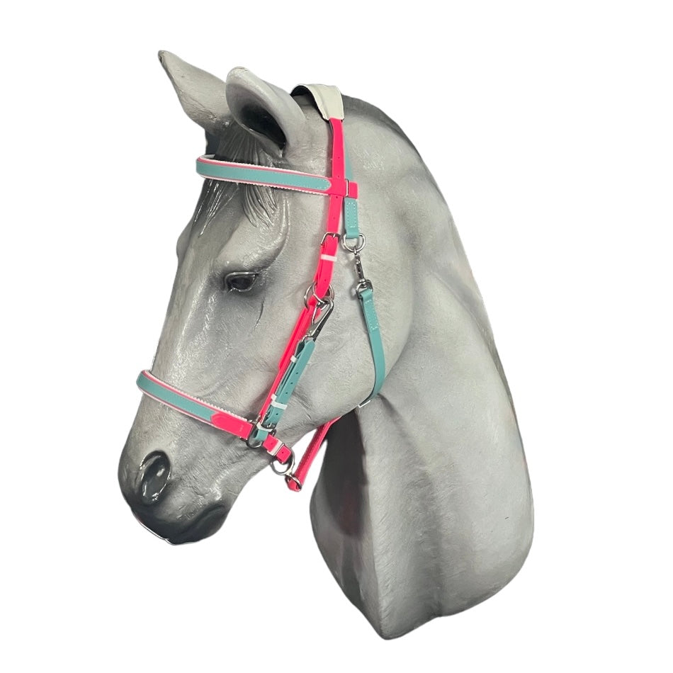 Displayed on a gray horse mannequin head, the LS Enduro Padded - Design your own bridle by LS Equestrian features an eye-catching custom design with vibrant pink, blue, and green straps, all crafted in New Zealand against a pristine white background.