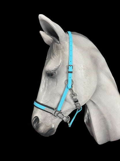 A gray horse mannequin head is showcased against a black background, adorned with an LS Equestrian LS Deux 2 Part Bridle Padded in bright blue. This handmade halter from New Zealand is crafted from durable Beta BioThane and features adjustable straps with metallic hardware.