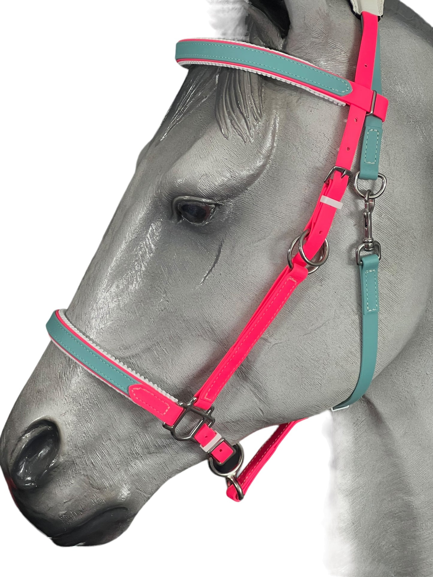 Profile view of a gray horse mannequin adorned with the eye-catching LS Enduro Padded bridle from LS Equestrian, featuring vibrant pink and teal straps with silver hardware. This custom design stands out against the white background, showcasing exceptional craftsmanship made in New Zealand.